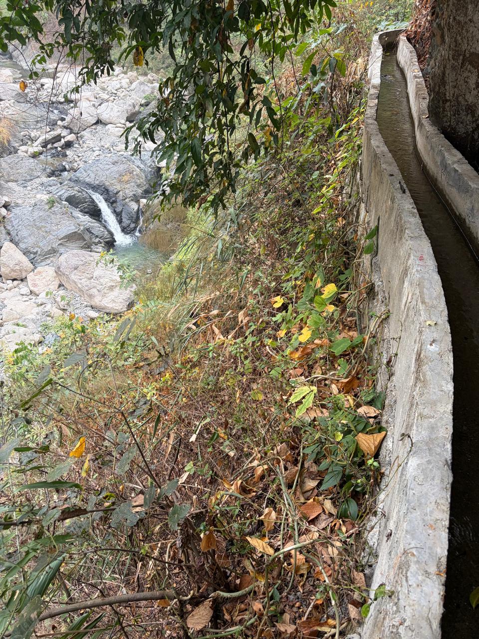 Lined irrigation canal alongside a natural stream