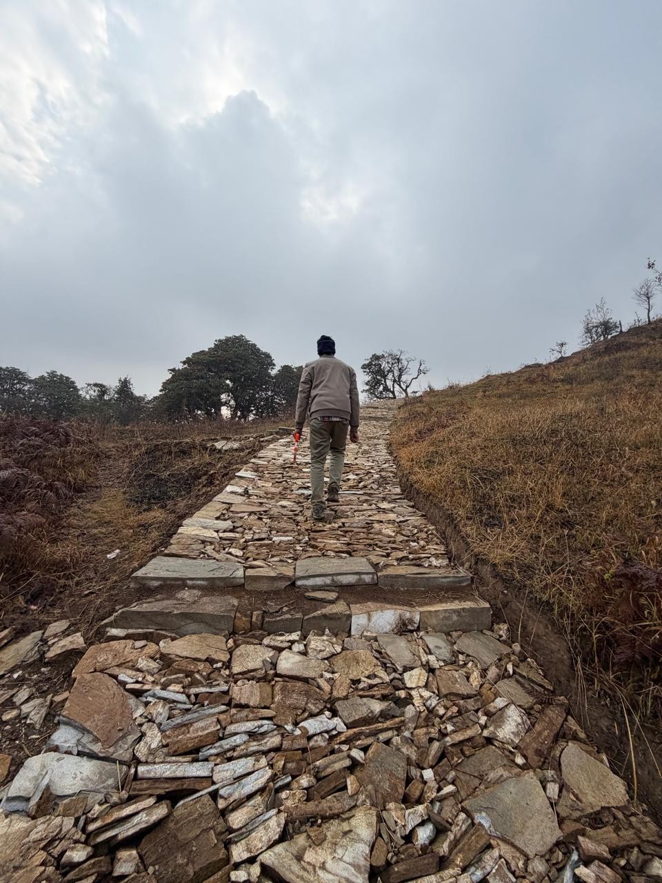 Stone-paved trail section through open hillside terrain